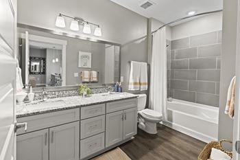 A bathroom with a large mirror and a toilet and a shower